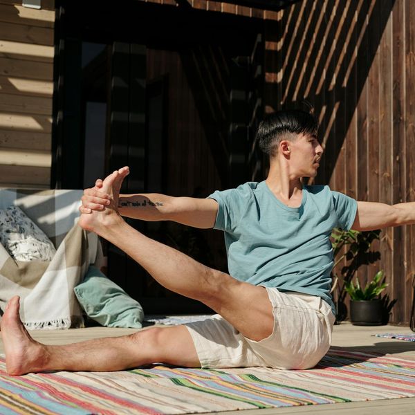 Person holding a difficult balancing yoga pose on one leg.